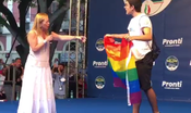 Con la bandiera arcobaleno sul palco di Giorgia Meloni. Lei scherza: “Me la vuoi lasciare, grazie?”